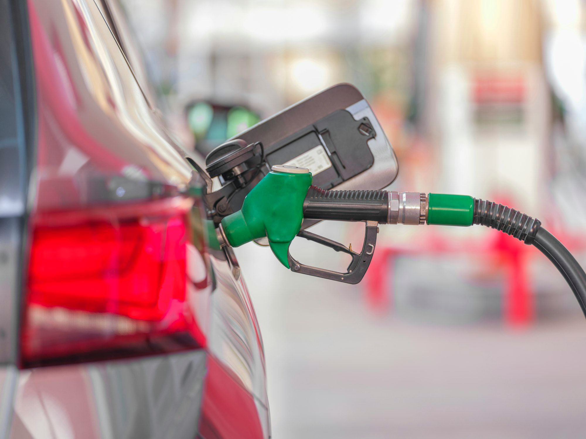 Een groen tankpistool in de tankopening van een auto