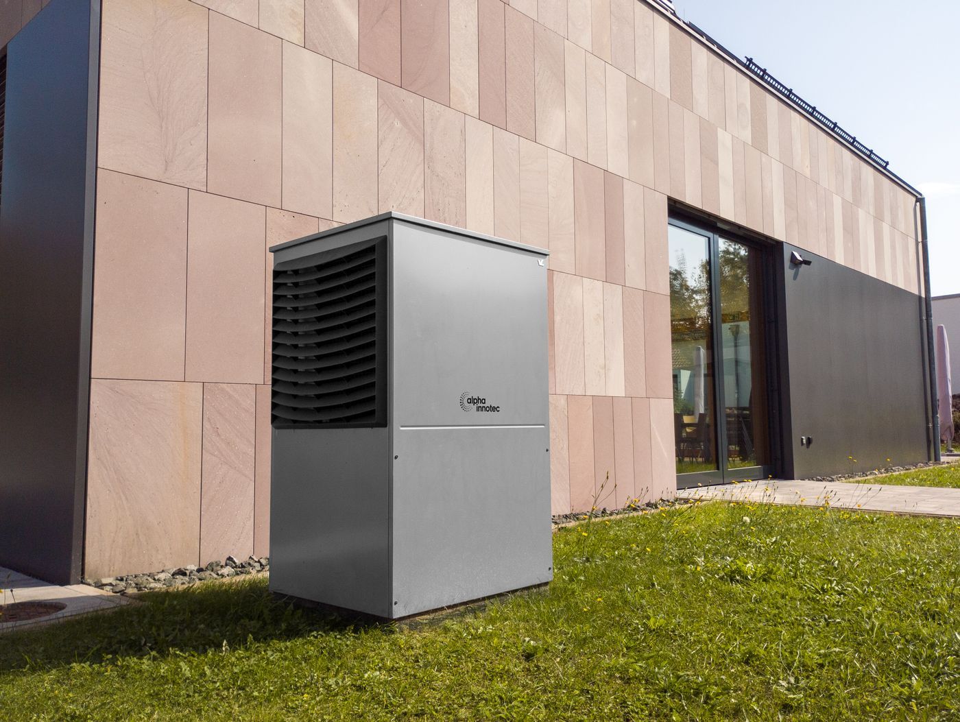 Warmtepomp buitenunit naast een moderne gevel